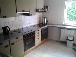 a kitchen with stainless steel appliances and a window at Monteurzimmer Alte Schule Heberndorf 1 in Wurzbach