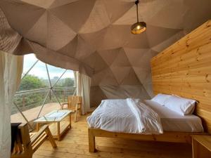 a bedroom with a bed with a geometric wall at L.T NATURE GLAMPS in Kodaikānāl