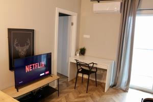 een woonkamer met een televisie en een tafel met een stoel bij Capital Towers Prime in Rzeszów