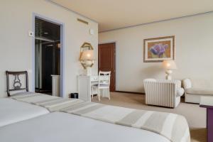 a hotel room with a bed and a desk at Pestana Bahia Praia Nature & Beach Resort in Vila Franca do Campo