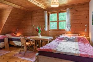 sypialnia z 2 łóżkami i stołem w drewnianym domku w obiekcie U Prezesa w mieście Lutowiska