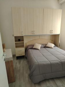 1 dormitorio con 1 cama grande y armarios blancos en LOFT, en Mezzolombardo