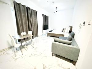 - un salon avec un canapé, une table et un lit dans l'établissement Mag 5 Spacious studio apartment, à Dubaï