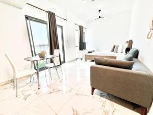 Mag 5 Spacious studio apartment في دبي: غرفة معيشة مع أريكة وطاولة