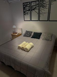 a large bed with two towels on top of it at Ocean Apartments in Ciudad Lujan de Cuyo