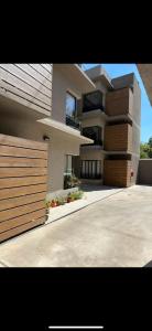 a large building with a fence in front of it at Ocean Apartments in Ciudad Lujan de Cuyo