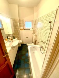 a bathroom with a tub and a sink and a toilet at Mountain apartment with marvelous view near slopes in Barzio