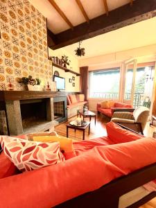 a living room with orange furniture and a fireplace at Mountain apartment with marvelous view near slopes in Barzio