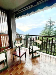 a room with two chairs and a table on a balcony at Mountain apartment with marvelous view near slopes in Barzio