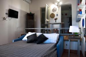 1 dormitorio con 1 cama azul y 2 almohadas en Casetta Licciardello, en Trecastagni