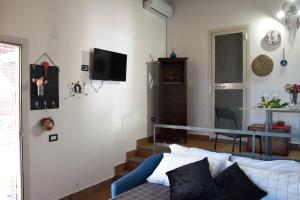sala de estar con cama y TV en la pared en Casetta Licciardello, en Trecastagni
