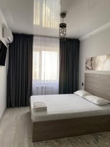 Un pat sau paturi într-o cameră la Апартаменты в районе Болашак