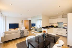 uma cozinha e sala de estar com uma mesa e um sofá em The Battersea Park Place - Amazing 2BDR Flat with Terrace em Londres