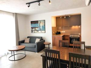 a living room and kitchen with a couch and a table at Luna Holiday Complex in Mellieħa
