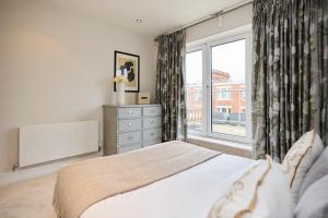 um quarto com uma cama e uma grande janela em The Battersea Park Place - Amazing 2BDR Flat with Terrace em Londres