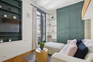 - un salon avec un canapé et une télévision dans l'établissement Central Paris - Le Marais - CityApartmentStay, à Paris