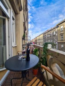 una mesa en un balcón con una copa de vino en MADEA apartman, en Zagreb