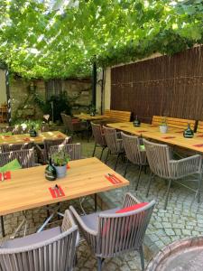 a patio with wooden tables and chairs with plants at Gasthaus Winzerstube & Hotel in Rödelsee