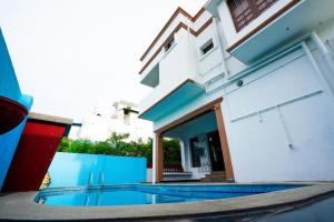 a swimming pool in front of a building at Bay Minaret Villa - Lavish 4BHK Beach House at Ecr Uthandi in Chennai +39 photos