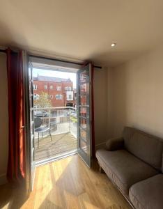 a living room with a couch and a sliding glass door at Harbourside Haven - One Bed Apartment with Balcony in Bristol