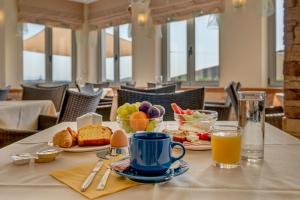una mesa con alimentos para el desayuno y una taza de zumo de naranja en Sunrise Beach Suites, en Azolimnos