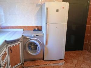 a refrigerator next to a washing machine in a kitchen at Comfort and quiet apartment in Ajloun