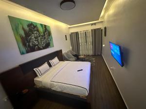 a hotel room with a bed and a tv at Ruhondo Beach Resort in Ruhengeri