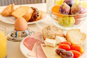 una mesa cubierta con platos de comida con pan y fruta en Sunrise Beach Suites, en Azolimnos