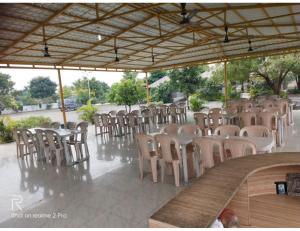 a group of tables and chairs in a pavilion at Shreeji Farm and Resort, Jalondar, Gujarat in Chāndawāri