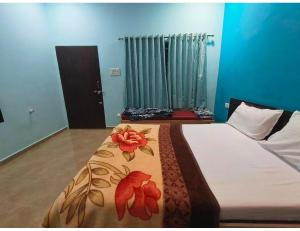 a bedroom with a bed with a blanket with flowers on it at Shreeji Farm and Resort, Jalondar, Gujarat in Chāndawāri