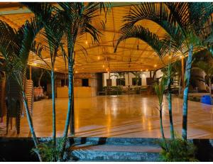 a large room with palm trees in the middle at Shreeji Farm and Resort, Jalondar, Gujarat in Chāndawāri