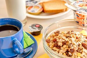 un tazón de granola junto a una taza de café en Sunrise Beach Suites, en Azolimnos