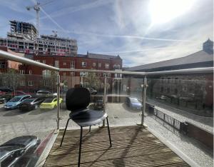 a chair sitting on a balcony with a view of a city at Harbourside Haven - One Bed Apartment with Balcony in Bristol