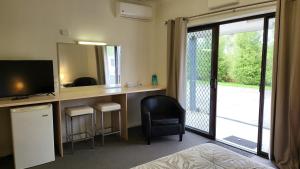 a room with a desk with a television and a mirror at KooWeeRup Motel in Koo-Wee-Rup