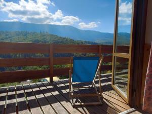 a chair on a deck with a view of the mountains at Gazdówka na Mosornym Groniu in Zawoja