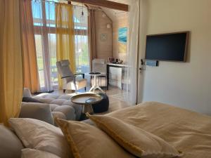 um quarto com uma cama e uma sala de estar com televisão em Beachboog LAHEMAA em Kuusalu