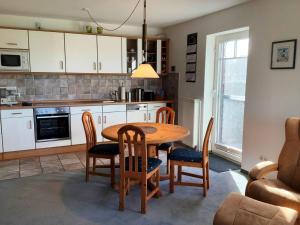 eine Küche und ein Esszimmer mit Tisch und Stühlen in der Unterkunft Feldblick-Wohnung in der N he der Ostsee in Schlagsdorf