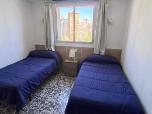 Duas camas num quarto com uma janela em Tor Serena-Fincas Benidorm em Benidorm