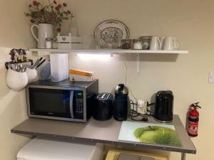 a counter top with a microwave and a fruit on it at Seaside Victorian Gate lodge in Warrenpoint