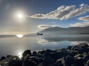 a boat on the water with the sun in the sky at Warrenpoint Gate lodge in Warrenpoint