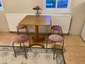 a wooden table with three chairs and a vase with flowers at Warrenpoint Gate lodge in Warrenpoint +21 photos