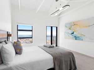 1 dormitorio blanco con 1 cama grande y ventanas en Blueberry Villa by Host Agents, en St Helena Bay