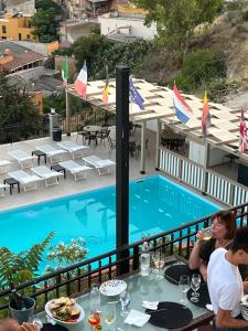 a group of people sitting at a table next to a swimming pool at B&B Montemare in Agrigento