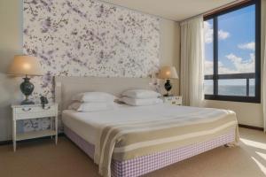 a bedroom with a bed with a floral wall at Pestana Bahia Praia Nature & Beach Resort in Vila Franca do Campo