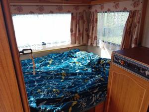 Dormitorio pequeño con cama con edredón azul en Campingfiz en Varzy