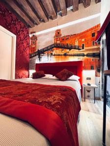 een slaapkamer met een groot rood bed en een trap bij Hotel al Graspo de Ua in Venetië