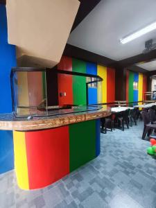 D & G Transient House في Pintuyan: غرفة بها جدران ملونة وطاولات وكراسي