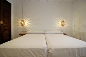 a bedroom with a large white bed with two lights at Villa Xarahiz in Jaraiz de la Vera