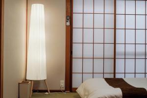 um quarto com uma cama e um grande candeeiro branco em USJ直达，2站5分钟!Meeno home西九条·美の宿亲子民宿· 马里奥手环有·大空间·出行便利 em Osaka