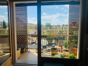Cette chambre dispose d'une fenêtre donnant sur un balcon avec des plantes en pot. dans l'établissement Appart 61 m2, lumineux, sans vis à vis, balcon, à Montreuil